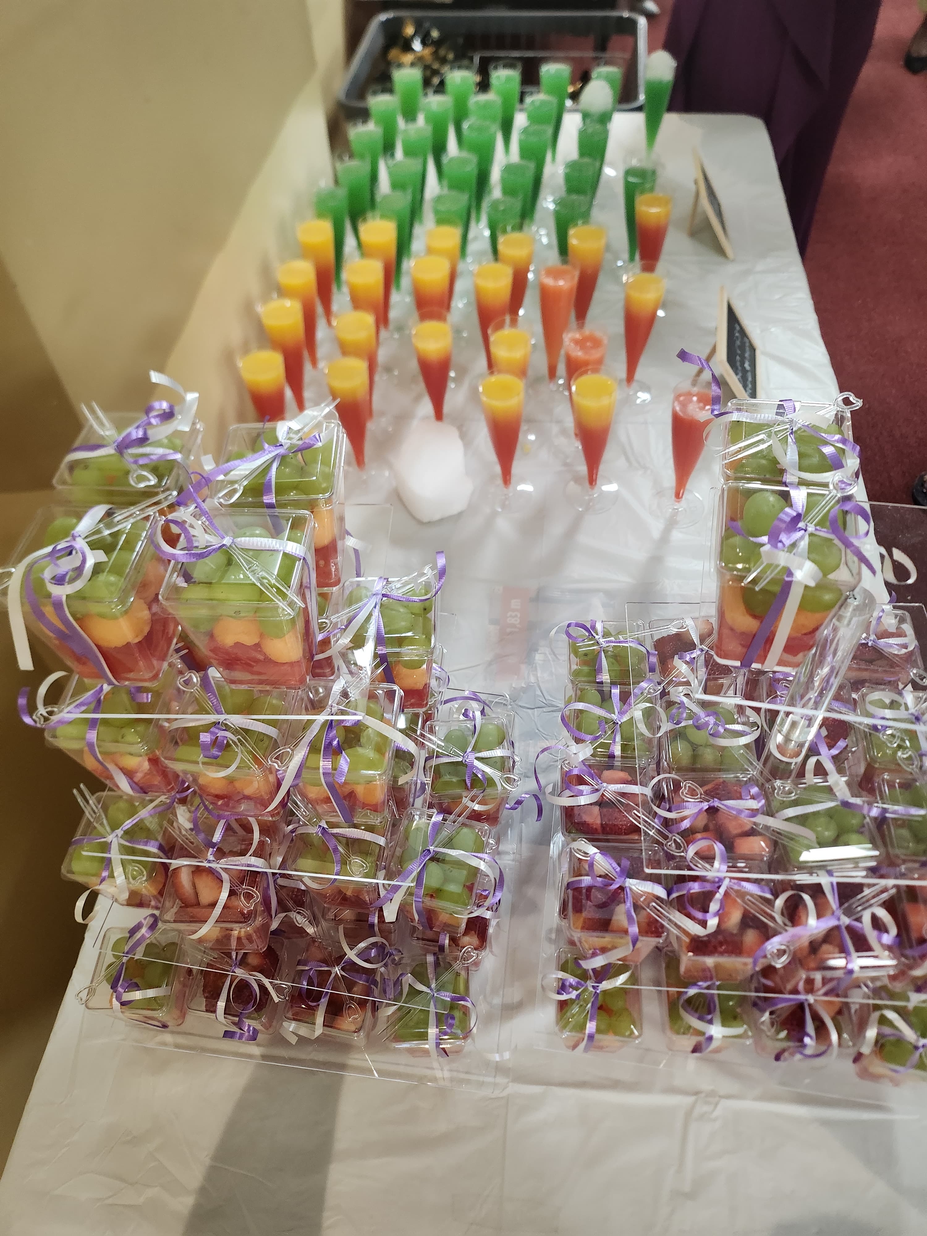 Individual fruit cups and colorful juice shots