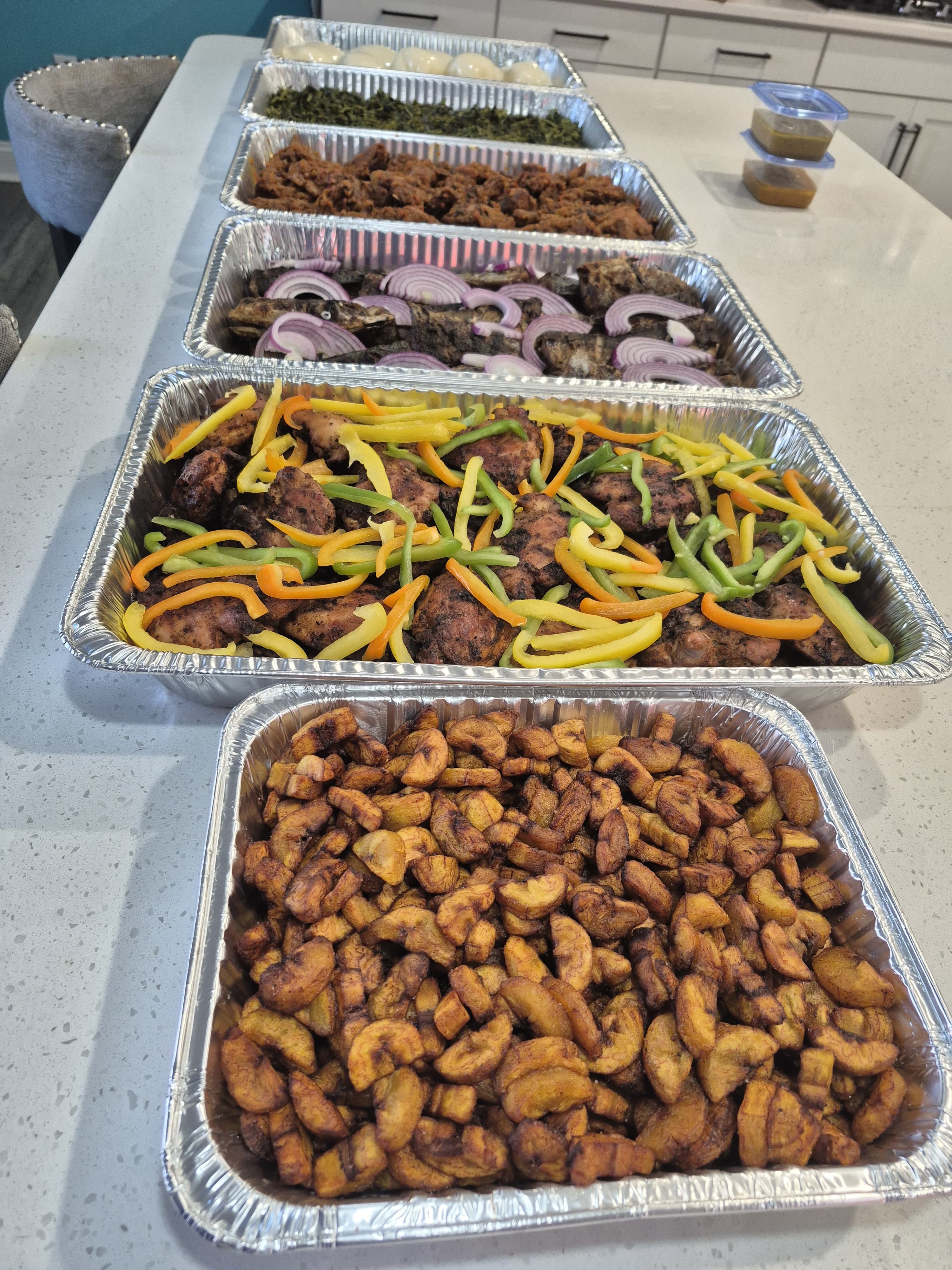 Meal prep containers with fried plantains, grilled chicken with peppers, and more